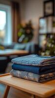 A stack of neatly folded fabrics in a cozy living room with a warm atmosphere photo