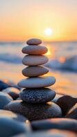 Balanced stones stacked on a beach during sunset with waves gently lapping at the shore photo