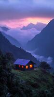A cozy tent glows warmly in the mountains at dusk surrounded by misty peaks photo