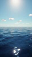 Calm ocean waters under a clear blue sky with wispy clouds during daylight hours photo