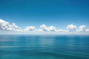 Calm blue ocean water under clear sky with fluffy clouds during midday sunlight photo