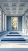 A tranquil yoga studio with blue mats and large windows overlooking autumn trees photo