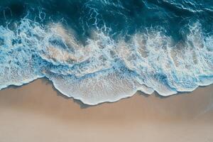 Gentle ocean waves lapping against a sandy beach captured from above during daylight hours photo