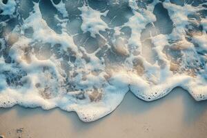 Gentle ocean waves lapping against a sandy beach captured from above during daylight hours photo