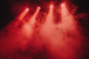 Bright red stage lights illuminate smoky atmosphere in a dramatic performance setting photo