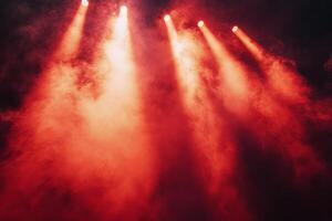 Bright red stage lights illuminate smoky atmosphere in a dramatic performance setting photo