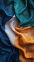 A vibrant close up of silk fabric arranged in a spiral with colors of orange, white, and green photo