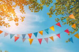 Brightly colored party flags waving under a clear blue sky during a sunny afternoon photo