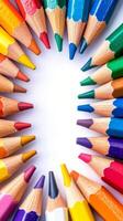 Brightly colored pencils arranged in a circular pattern on a white background for creative projects photo