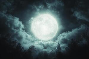 A bright full moon surrounded by dramatic clouds over a dark landscape at night photo