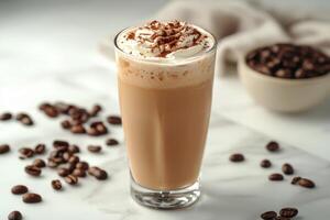 Creamy iced coffee topped with whipped cream and cocoa on a marble countertop with coffee beans photo