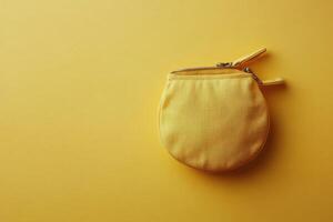 A bright yellow fabric coin purse rests on a vibrant yellow background photo
