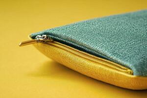 A bright yellow fabric coin purse rests on a vibrant yellow background photo