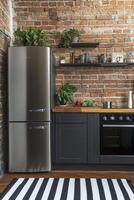 Modern kitchen with industrial accents and greenery, showcasing brick walls and sleek appliances photo