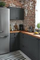 Modern kitchen with industrial accents and greenery, showcasing brick walls and sleek appliances photo