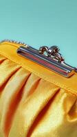 A close up view of a stylish yellow clutch purse with pleats and metallic clasp photo