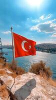 Turkish flag waving on a boat in the Bosphorus with stunning skies and bridge in the background photo