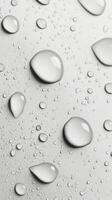 Raindrops on a smooth surface with a soft grayscale background in natural light photo