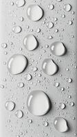 Raindrops on a smooth surface with a soft grayscale background in natural light photo