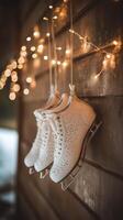 Elegant white ice skates hanging by twinkling lights in a cozy indoor setting during winter photo