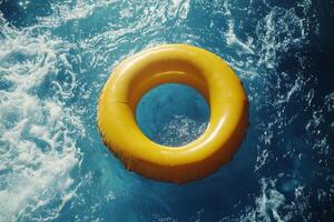 Yellow lifebuoy floating on vibrant blue water in a sunny outdoor swimming pool photo