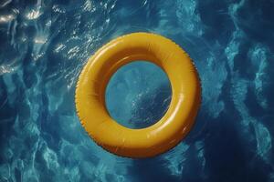 Yellow lifebuoy floating on vibrant blue water in a sunny outdoor swimming pool photo