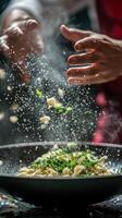 Chef adding herbs to a wok while cooking in a restaurant kitchen at night photo