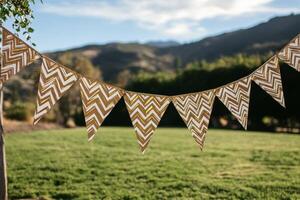 Colorful decorative flags hanging from a tree in a sunny garden during late afternoon photo