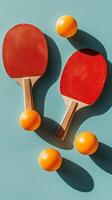 Two red table tennis paddles and a yellow ball on a blue background in a minimalistic arrangement photo
