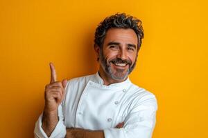 Chef smiling and posing against a bright yellow wall while preparing to share cooking tips photo