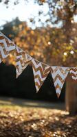 Decorative gold and white bunting strung between trees at a sunny outdoor gathering photo