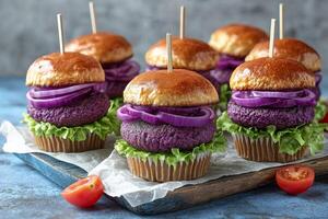 Unique colorful mini burgers with purple patties and fresh vegetables on display on a wooden platter photo