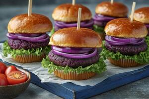 Unique colorful mini burgers with purple patties and fresh vegetables on display on a wooden platter photo