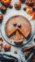 Autumn pumpkin pie with a playful design and festive decorations on a marble surface photo