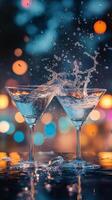 Two martini glasses clinking together with splashes in a dimly lit bar setting at night photo