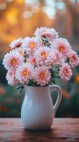 Fresh pink flowers arranged in a white pitcher on a wooden table in a garden setting during sunset photo
