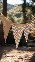 Decorative gold and white bunting strung between trees at a sunny outdoor gathering photo