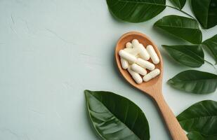 Natural health supplements on a wooden spoon surrounded by green leaves in a tranquil setting photo
