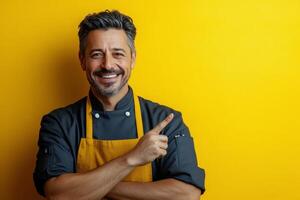 Chef smiling and posing against a bright yellow wall while preparing to share cooking tips photo
