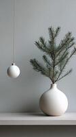 Elegant winter arrangement with evergreen branches and decorative ornaments on a light background photo