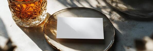 A glass of amber liquid rests on a marble surface illuminated by soft sunlight photo