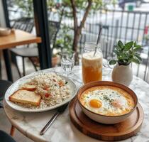 Delicious breakfast spread with fried rice, eggs, and a refreshing drink at a cozy caf photo