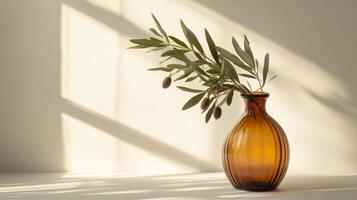Olive branches in a brown glass vase casting delicate shadows in sunlight photo