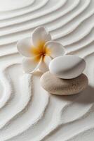 Tranquil arrangement of stones and flowers on textured sand pattern in a serene setting photo