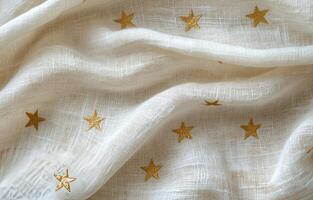 Soft white fabric adorned with golden stars, perfect for crafts or interior decor photo