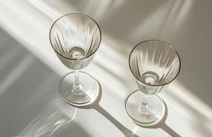 Elegant crystal glasses on a white surface with soft lighting during the afternoon photo