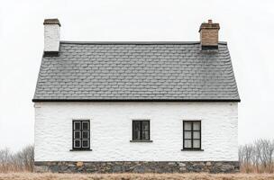 A minimalist white house with a sleek roof design against a cloudy sky in a serene landscape photo