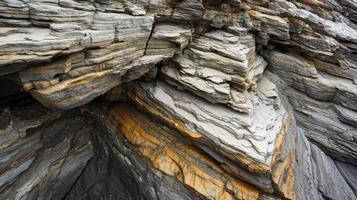 Close-up of layered rock formation with gray, brown, and orange hues. photo