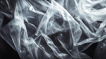 Abstract Wrinkled Transparent Plastic Sheet on Black Background photo