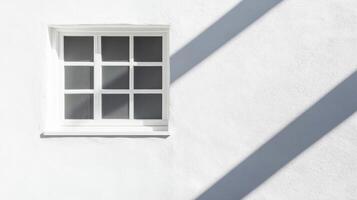 A Single White Window on a White Wall with Diagonal Shadows photo